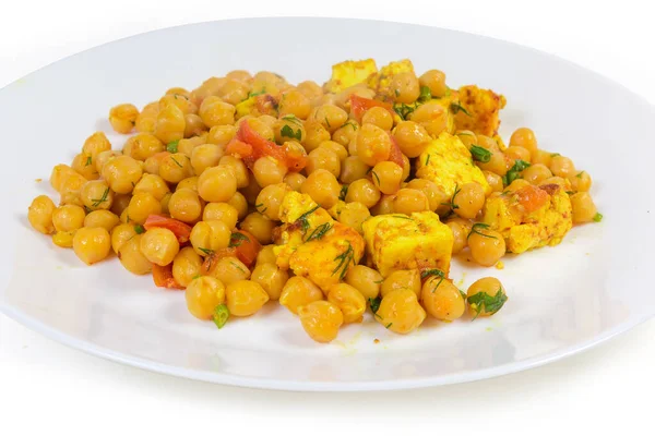 Boiled chickpeas, stewed with tomatoes, Adyghe cheese and greens on the white dish, fragment close-up on a white background — Stock Image Boiled Chickpeas Stewed Tomatoes Adyghe Cheese Greens White Dish Fragment Royalty Free Stock Photos