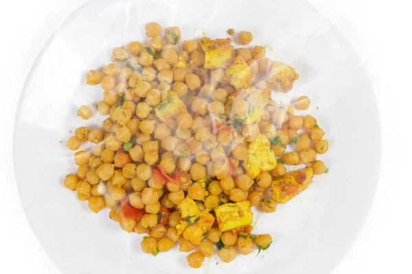 Hot boiled chickpeas, stewed with tomatoes, Adyghe cheese and greens on the white dish, top view fragment on a white background — Stock Image Hot Boiled Chickpeas Stewed Tomatoes Adyghe Cheese Greens White Dish Stock Picture