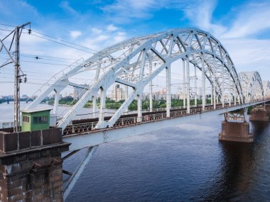 Demiryolu köprüsünün, nehrin üzerinde çelik perçinli kemer kirişleriyle üç açıklığı var. Darnytskyi Demiryolu Köprüsü 'nün Parçası Dinyeper Nehri, Kyiv, Ukrayna