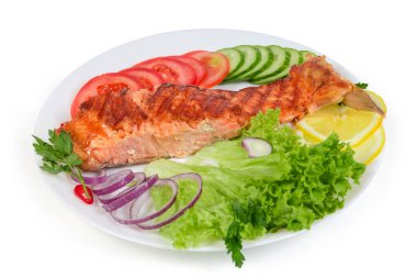 Sebze ve sebzeli ızgara fileto servis ediliyor. Beyaz arka planda, seçici odak noktasında yakın plan.