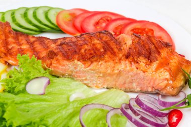 Sebze ve sebzelerin arasında ızgara alabalık filetosu, seçici odak noktasında yakın plan.