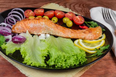 Sebze ve sebzelerin arasında ızgara alabalık filetosu. Seçici odak noktasında yakın plan.