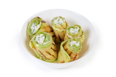 Izgarada uzun dilimler halinde yumuşak peynir ve sebze dolu sebze ilikleri beyaz arka plandaki kasede uzanıyor.