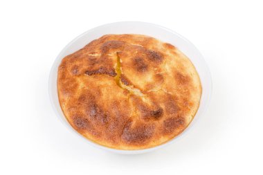 Beyaz arka planda küçük beyaz kasede fırınlanmış lor suflesi.