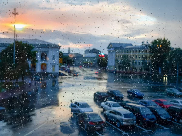 雨の間の窓のペイン 夕日で覆われた湿ったガラスを通してぼやけた街並み 内部ビュー — ストック写真