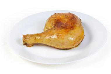 Dıştan kızarmış tavuk budu kıtır kıtır ve içeriden sulu beyaz tabakta yakın plan beyaz bir fonda.