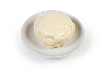 Beyaz bir arka planda çay tabağındaki salamura peynirden çıkarılmış küçük bir kafa.