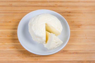 Bir salamuradan çıkartılan ve bambu ahşap yüzeyinde kısmen kesilmiş küçük bir peynir kamışı.