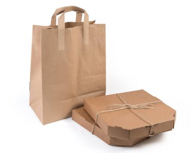 Teslimat için tek kullanımlık ekolojik paketlerde iki pizza ve diğer yemekler. Beyaz arka planda doğal sicim ve kağıt torbayla bağlanmış pizza kutuları.