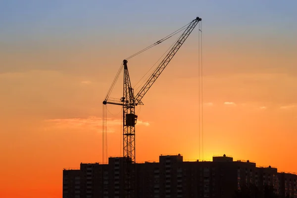 Silueta Věžového Jeřábu Nad Multistorickou Budovou Výstavbě Pozadí Západu Slunce — Stock fotografie