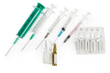 Tek kullanımlık plastik şırıngalar. Derialtı ve kas içi iğnelerle farklı boyutlarda. Beyaz arka planda ilaç ampulleri.