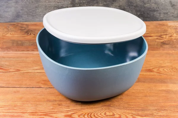空塑料蓝灰色色拉碗 稍开灰色盖子 放在乡村餐桌上 — 图库照片