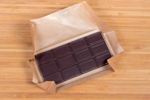 Bar Chocolate Escuro Com Nozes Papel Aberto Sobre Superfície Madeira — Fotografia de Stock