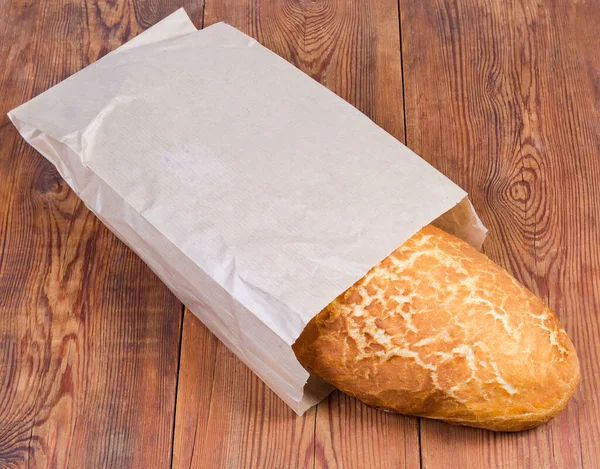 Whole Oval Loaf Wheat Bread Netted Crust Partly Paper Packing — Stock Photo, Image