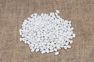 Çuval bezi üzerinde büyük, çiğ fasulye yığını.