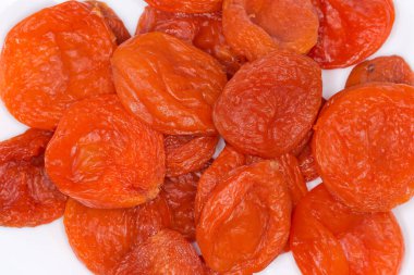 Beyaz bir tabakta kurumuş füme kayısılar, üst kısmı yakın plan.