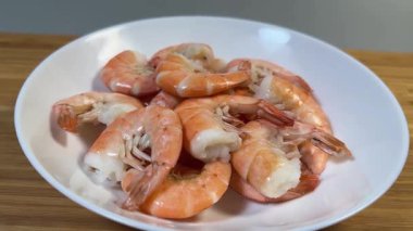 Kaynamış kabuksuz kuyruk beyaz tabak üzerinde kral karidesleri.