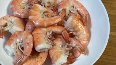 Kaynamış kabuksuz kuyruk beyaz tabak üzerinde kral karidesleri.