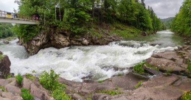 Prut Nehri üzerindeki Yaremche Şelalesi olarak da bilinen Probiy Şelalesi Ukrayna Karpatları 'nda bahar bulutlu bir günde panoramik manzara