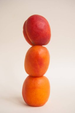 Üç tüm ve taze kayısı yığını birbirinin üstüne dengeli