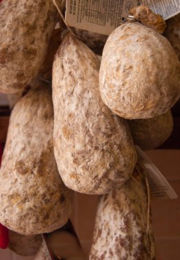 Sokak gıda mağazaları dışında duvara asılı katır Cojoni denilen tipik salam