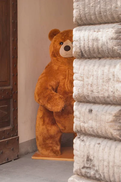 A big brown plush bear at an entrance