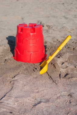 Kırmızı kova ve çocuklar için sarı kepçe