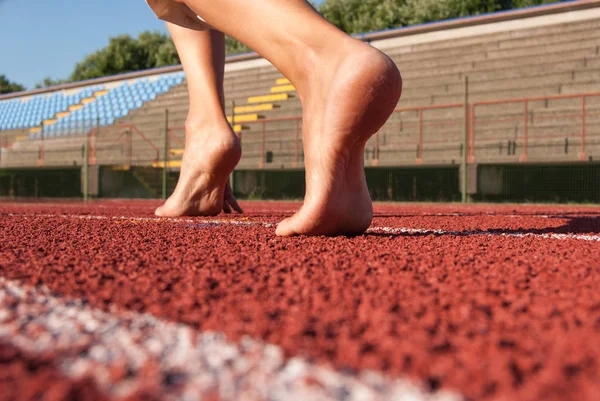 Çıplak ayak atletik yüzük kırmızı şeritli yola hazır
