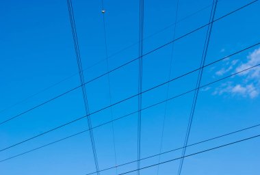 Yüksek gerilim kablolarının mavi gökyüzünde geometriler