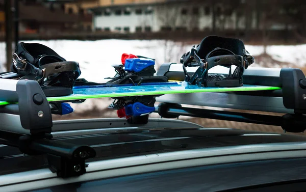 Bir snowboard ve kayak arabanın çatıda iki çift