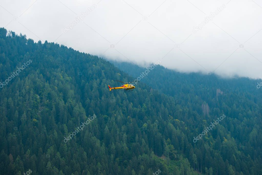 Flight of a yellow assistance helicopter during a mission