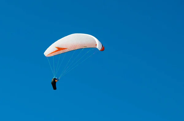 Descenso de un parapente en el cielo azul y claro —  Fotos de Stock