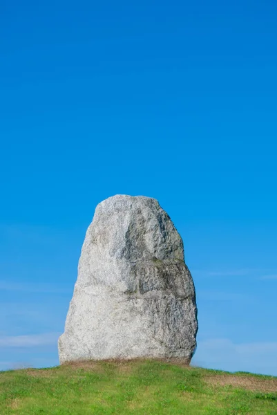 Green hill with a big vertical rock boulder on the top — Stock Photo, Image