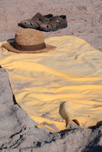 Sandálias de chapéu isolado e toalha na praia — Fotografia de Stock
