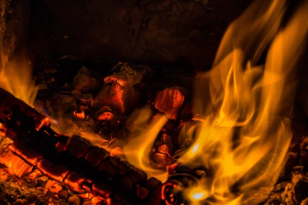 Uma bela textura horizontal de um incêndio em chamas em um fundo preto com faíscas — Fotografia de Stock