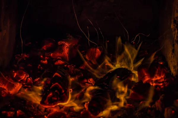 Una hermosa textura horizontal de un fuego ardiente sobre un fondo negro con chispas — Foto de Stock