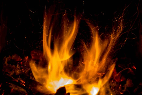 Una hermosa textura horizontal de un fuego ardiente sobre un fondo negro con chispas — Foto de Stock
