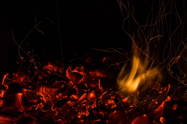 Una hermosa textura horizontal de un fuego ardiente sobre un fondo negro con chispas —  Fotos de Stock