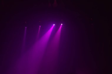 Dört güzel kırmızı pembe ışınlarından sahne ışıkları karanlık bir arka plan üzerinde bir grup sahne konser göstermek için yanar