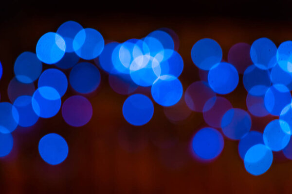 The abstract beautiful blurred background with a group of blue circles from lighted lamps can be used for a decoration