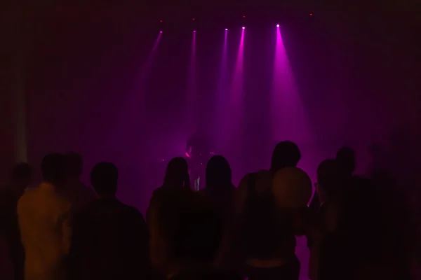 As silhuetas escuras de um grupo de pessoas no concerto de rock — Fotografia de Stock