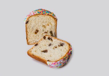 Sarı kek üzümlü ve renkli tatlı dekorasyonu bir yarıda kesilerek ile beyaz çikolata soslu beyaz bir arka plan üzerinde ve bu sabah Paskalya veya kahvaltı çay için kullanılabilir.