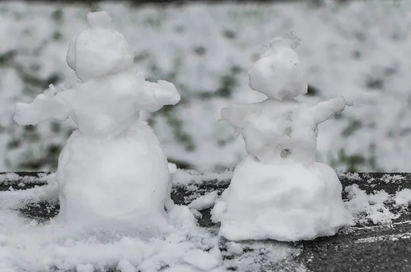 Två Små Grov Snögubbar Med Snö Finns Suddiga Grå Bakgrunden — Stockfoto