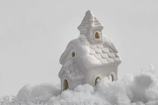 Piękny fantastyczny mały biały dom z żółtego światła w oknach na tle białego śniegu wieczorem wakacje w zimie — Zdjęcie stockowe
