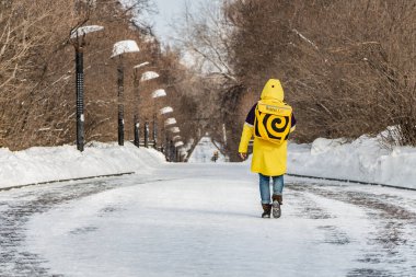 Yekaterinburg, Sverdlovsk Rusya-03 03 2018: sarı özel kıyafetler içinde bir Yandex kurye gıda teslim beyaz kar ve siyah ve beyaz sokak aydınlatma fenerleri bir grup ile karlı bir yol boyunca gider 
