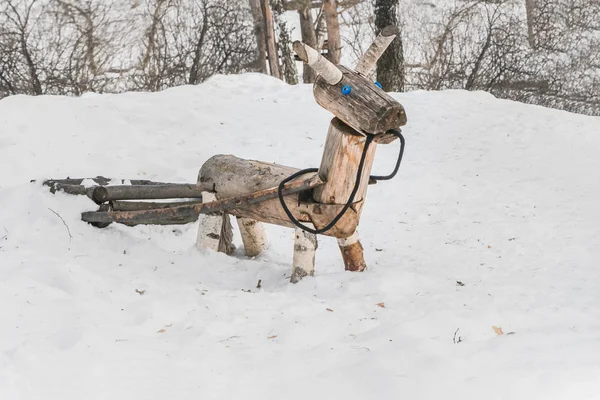 Un cavallo giallo di legno o un asino con una carrozza per bambini nel parco giochi nel parco invernale — Foto Stock