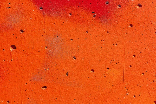 Bella struttura orizzontale di parte del vecchio muro di cemento dipinto di colore arancione con fori sulla foto — Foto Stock