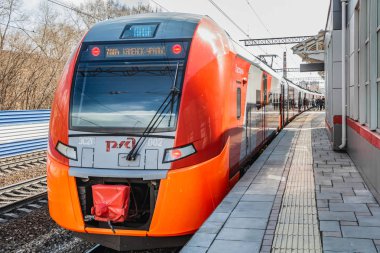 Yekaterinburg, Sverdlovsk Rusya - 24 04: 2019: Yeni kırmızı ve turuncu elektrikli tren Lastochka ilkbaharda Rus demiryolu istasyonuna vardı.