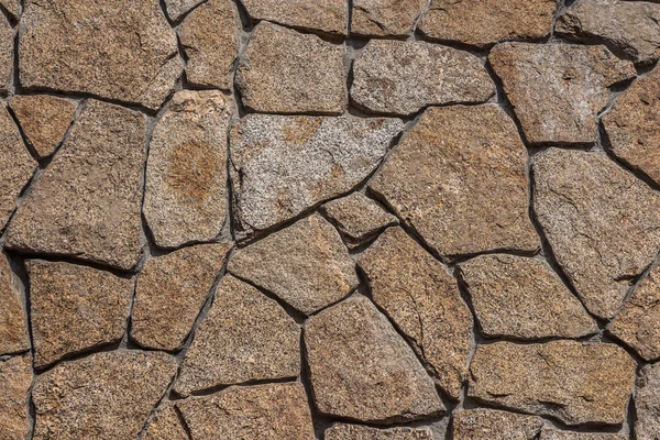 Schöne horizontale Textur eines Teils einer natürlichen Granitsteinmauer in orange und grau auf dem Foto — Stockfoto