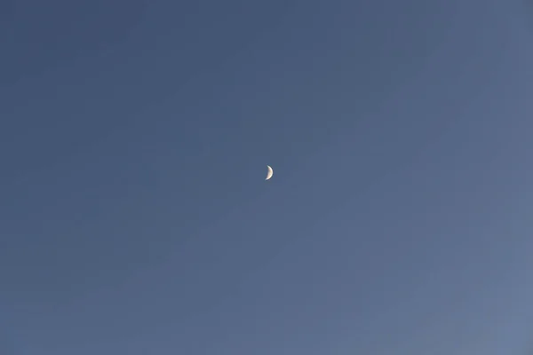 Желтая маленькая растущая луна на голубом небе — стоковое фото